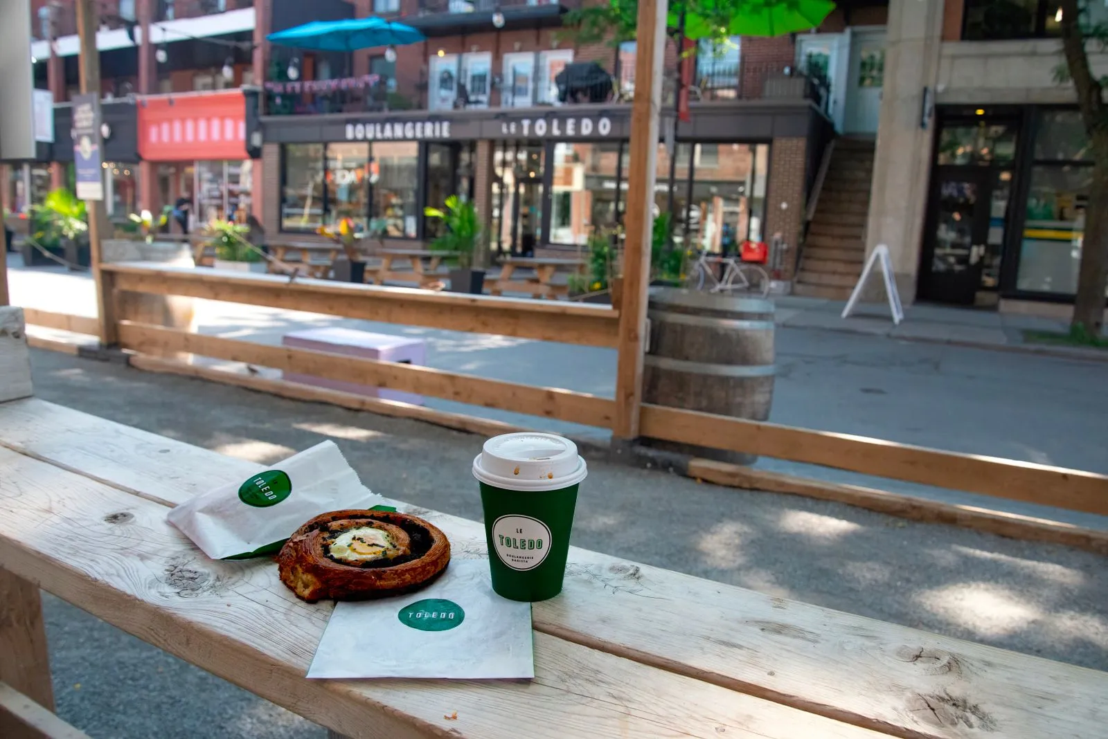 A cozy outdoor cafe setting with coffee and pastry on a rustic table.